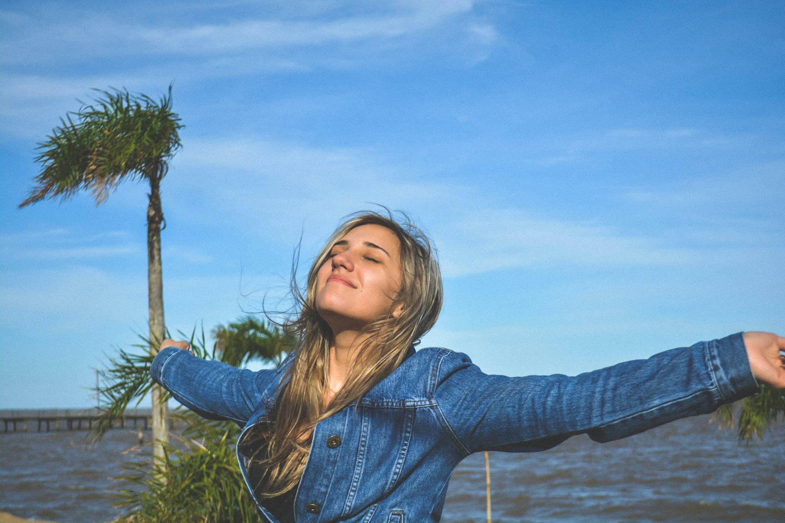 woman spreading arms near body of water